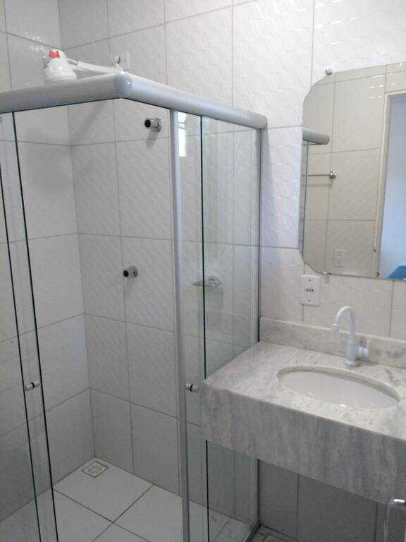 a bathroom with a shower, sink, and mirror 